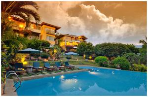 邦劳亚摩瑞拉度假村的一个带椅子和遮阳伞的游泳池的度假酒店