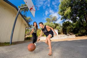 纽黑文BIG4 Ingenia Holidays Phillip Island的男子和女子用 ⁇ 子打篮球