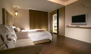 礁溪华阁温泉饭店的一间卧室配有一张床和一台平面电视