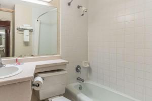 布雷纳德Econo Lodge的一间带水槽、浴缸和卫生间的浴室