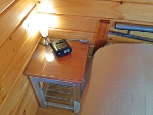 皮克顿皮克顿露营公园酒店的一张桌子,上面有闹钟,放在床边