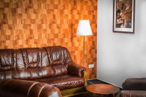 马汀VILLA CENTRUM APARTMÁNY s RAŇAJKAMI A SAUNOU的客厅里一张棕色的皮沙发,配有灯