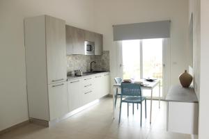斯廷蒂诺197 Pozzo San Nicola的厨房配有白色橱柜和桌椅