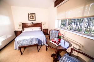 卡瓦尼亚斯Alda Cabanas Playa的一间卧室配有一张床、一张桌子和一个窗户。
