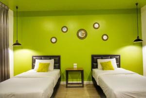 清莱梅诺尼旅馆的绿墙客房的两张床