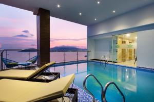 芽庄Crown Hotel Nha Trang的一个带椅子的游泳池,享有海景