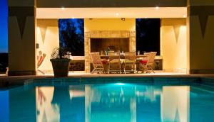 克尼斯纳天堂别墅宾馆的一个带桌椅和壁炉的游泳池