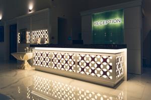 普里莫尔斯科Hotel Perla Beach Luxury - All Inclusive & Free Beach Access的室内带灯的前台柜台