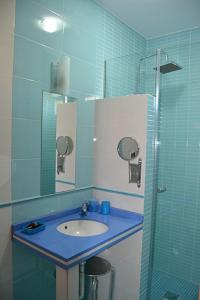 萨尔萨德格拉纳迪利亚Casa El lince de Granadilla, Norte provincia Cáceres, WIFI, Parque infantil, HIDROMASAJE, garaje, LAVAVAJILLAS的蓝色的浴室设有水槽和淋浴