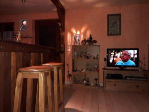 Sainte-Croix-aux-MinesGite的一间带电视和2张凳子的客厅