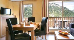 伊索拉2000Résidence mmv Les terrasses d'Isola的一间带桌椅的用餐室和一个阳台