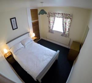 基尔Cosy Keel Cottage的卧室配有白色的床和窗户。