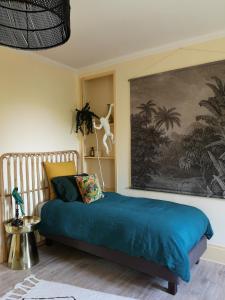 Asnières-sur-Oise勒克洛德菲住宿加早餐旅馆的卧室配有一张床,墙上挂有绘画作品