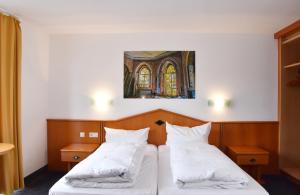 门兴格拉德巴赫Palazzo Hotel的一间卧室设有两张床,墙上挂着一幅画