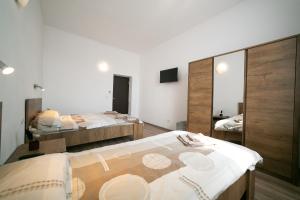 阿拉德Boul Rosu Residence的一间卧室配有两张床和镜子