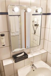 门兴格拉德巴赫Palazzo Hotel的一间带水槽和镜子的浴室