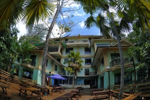 甘榜布提尔婆罗洲热带雨林度假村的前面有桌子和棕榈树的酒店