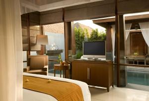 塞米亚克卡雅纳酒店的一间带电视的卧室和一间带游泳池的房间