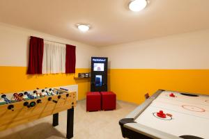 罗孚尔Haus Central Lofer的一间设有乒乓球桌和电子游戏的房间