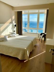 穆希亚Hotel La Cruz的一间卧室设有一张大床,享有海景