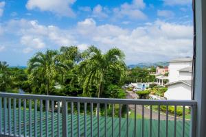 Morne Rouge塞尔斯塔酒店的阳台享有大海和棕榈树的景致。