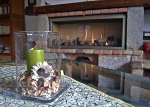 奇维泰拉阿尔费德纳Casa Hotel Civitella的壁炉前的桌子上放着蜡烛和花朵