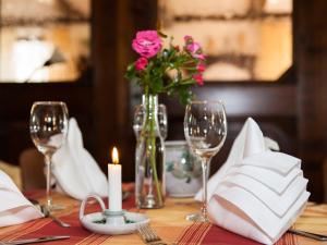 Tannenberg族姆哈默兰德酒店的一张带蜡烛的桌子和一个带粉红色花卉的花瓶