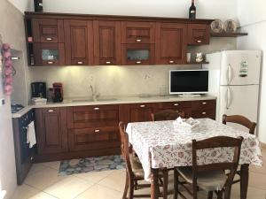 滨海波利尼亚诺Casa Sirena, Locazione Turistica的厨房配有桌子和白色冰箱。