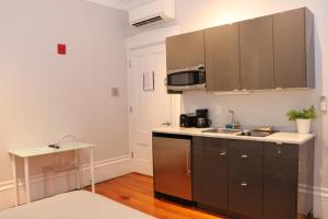 波士顿Downtown Beacon Hill, Convenient, Comfy Studio #1的厨房配有水槽和微波炉