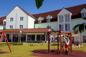 路茨曼贝格库尔兹特姆恩酒店的一群儿童在大楼前的游乐场玩耍