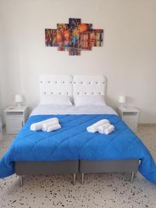 巴勒莫Casagioiosa18的一间卧室配有蓝色的床和2条毛巾