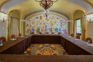 圣胡安艾尔康文托酒店的大房间设有一张桌子,墙上挂着一幅画