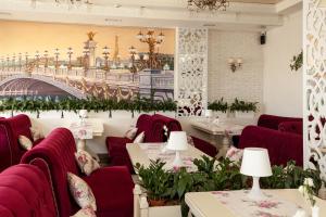 伊万诺-弗兰科夫斯克Mon Ami Hotel的餐厅设有红色椅子和一座桥
