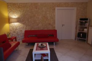 诺托尼奇亚度假屋的客厅配有红色的沙发和桌子