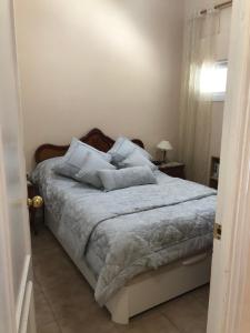 贝纳尔马德纳Malibu Playa Apartamento的一间卧室配有带白色床单和枕头的床。
