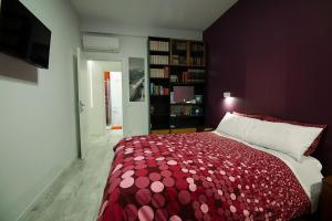 罗马德利兹伊法布里奇奥旅馆的一间卧室配有一张带红色和白色床罩的床。