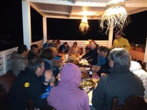 米勒福特ITRANE GUEST HOUSE的一群坐在桌子旁吃食物的人