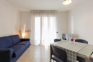 维罗纳Appartamento Verona Fiera e Centro的客厅配有蓝色的沙发和桌子