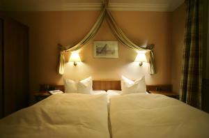 埃伦德格鲁恩塔纳曼德霍尔酒店的配有白色枕头的酒店客房内的两张床