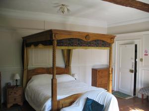 切姆乐富门住宿加早餐旅馆的卧室配有带白色床单的木制天蓬床