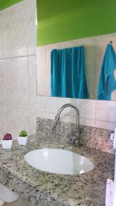 巴拉格兰德Pousada Barra Sol的浴室柜台配有水槽和蓝毛巾