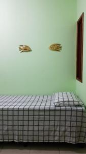 巴拉格兰德Pousada Barra Sol的墙上有两块动物板的房间里一张床位