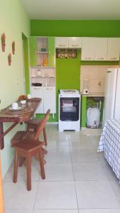 巴拉格兰德Pousada Barra Sol的厨房设有绿色的墙壁、桌子和炉灶。