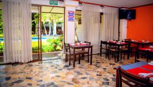 圣萨尔瓦多圣塔埃伦娜酒店的一间带桌椅的餐厅和一个游泳池