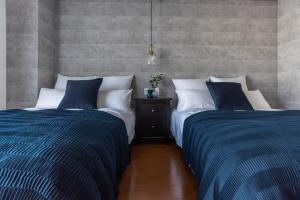 大阪Villa Penthouse Tenma的卧室内两张并排的床