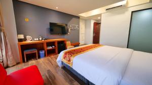 马公安泊海景旅店的酒店客房带白色的床和红色椅子