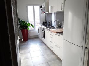 巴黎Apartment with Car Park - Bastille Neighborhood的厨房配有白色家电,铺有瓷砖地板。