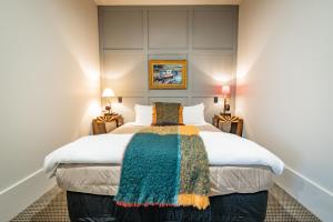 奥玛鲁Poshtel的一间卧室配有一张带彩色毯子的床