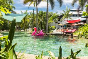 凯恩斯Summer House Backpackers Cairns的度假村游泳池里穿着粉红色服装的人