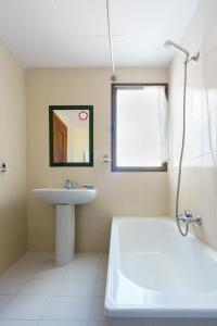 莫特里尔Hotel Costa Andaluza的浴室配有盥洗盆、浴缸和盥洗盆